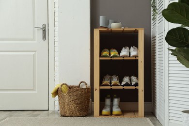 Photo of Different footwear on shelves in entryway. Shoe storage
