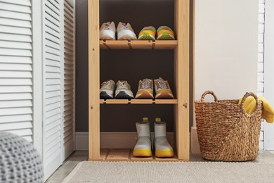 Photo of Different footwear on shelves in entryway. Shoe storage