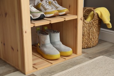 Photo of Different footwear on shelves in entryway, closeup. Shoe storage