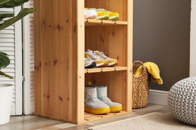 Photo of Different footwear on shelves in entryway. Shoe storage