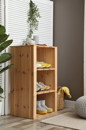 Photo of Different footwear on shelves in entryway. Shoe storage