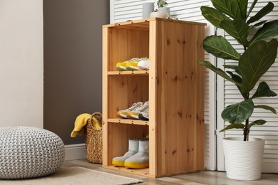 Photo of Different footwear on shelves in entryway. Shoe storage