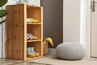 Photo of Different footwear on shelves in entryway. Shoe storage