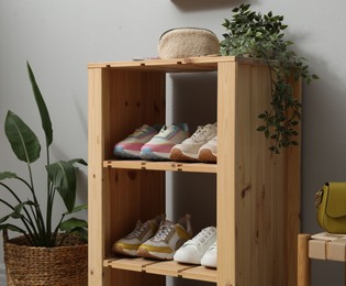 Photo of Different footwear on shelves in entryway. Shoe storage