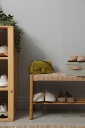 Photo of Different footwear on shelves in entryway. Shoe storage