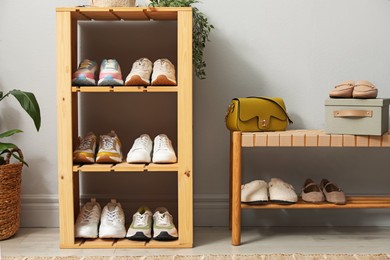 Photo of Different footwear on shelves in entryway. Shoe storage