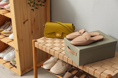 Photo of Different footwear on bench indoors. Shoe storage