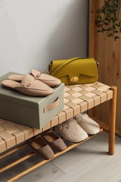 Photo of Different footwear on bench indoors. Shoe storage