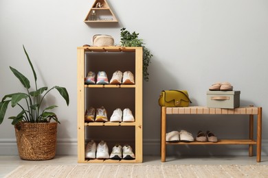 Photo of Different footwear on shelves in entryway. Shoe storage
