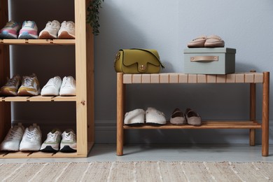 Photo of Different footwear on shelves in entryway. Shoe storage
