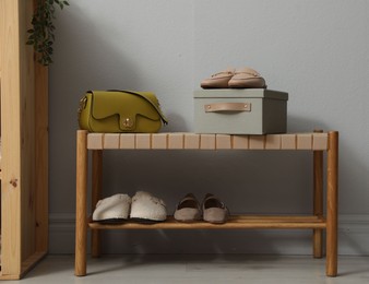 Photo of Different footwear on bench indoors. Shoe storage