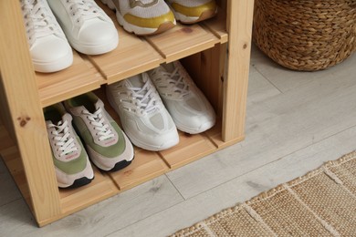 Photo of Different footwear on shelves indoors, closeup. Shoe storage