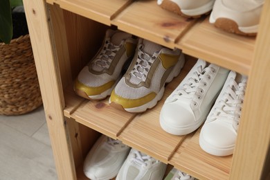 Photo of Different footwear on shelves indoors, closeup. Shoe storage