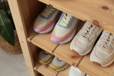 Photo of Different footwear on shelves indoors, closeup. Shoe storage