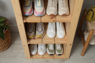 Photo of Different footwear on shelves in entryway, closeup. Shoe storage