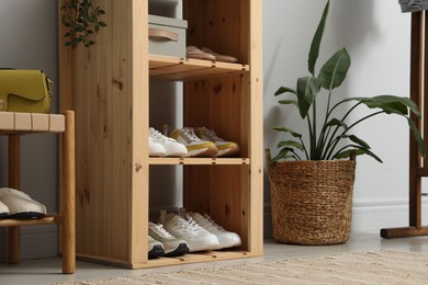 Photo of Different footwear on shelves in entryway. Shoe storage
