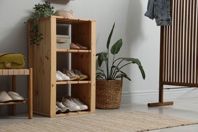 Photo of Different footwear on shelves in entryway. Shoe storage
