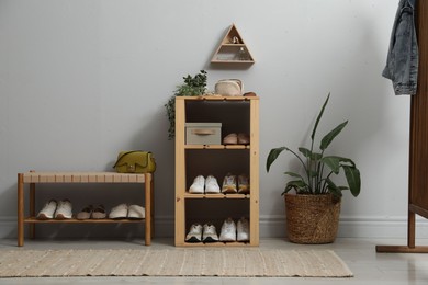 Photo of Different footwear on shelves in entryway. Shoe storage