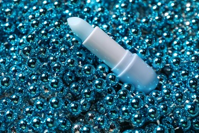 Photo of Moisturizing lip balm on Christmas decor, closeup. Winter care