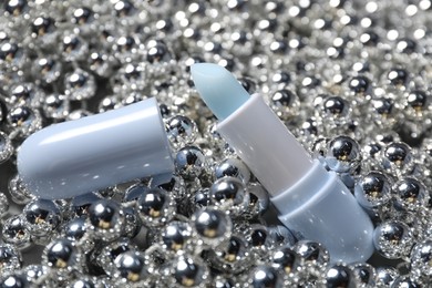 Photo of Moisturizing lip balm on Christmas decor, closeup. Winter care