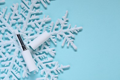 Photo of Moisturizing lip balm and Christmas decor on light blue background, flat lay. Space for text