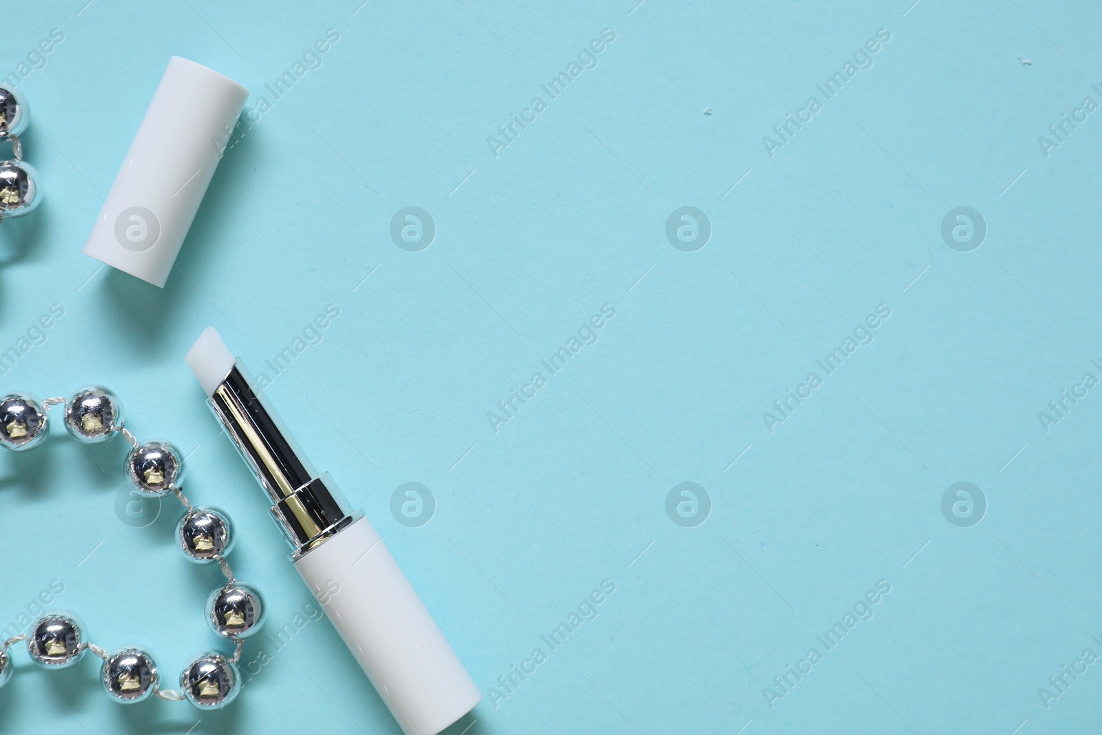 Photo of Moisturizing lip balm and Christmas decor on light blue background, flat lay. Space for text
