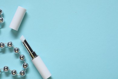 Photo of Moisturizing lip balm and Christmas decor on light blue background, flat lay. Space for text