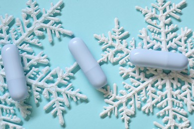Photo of Moisturizing lip balm and Christmas decor on light blue background, flat lay. Winter care