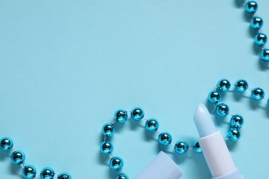 Photo of Moisturizing lip balm and Christmas decor on light blue background, flat lay. Space for text