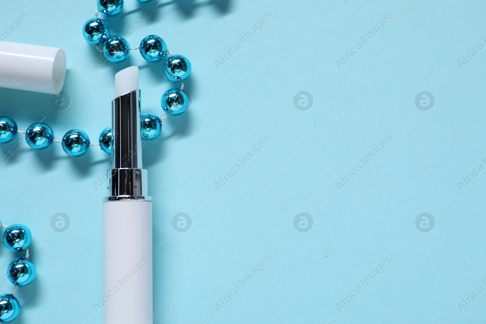 Moisturizing lip balm and Christmas decor on light blue background, flat lay. Space for text Photo of Moisturizing lip balm and Christmas decor on light blue background, flat lay. Space for text
