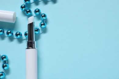 Photo of Moisturizing lip balm and Christmas decor on light blue background, flat lay. Space for text