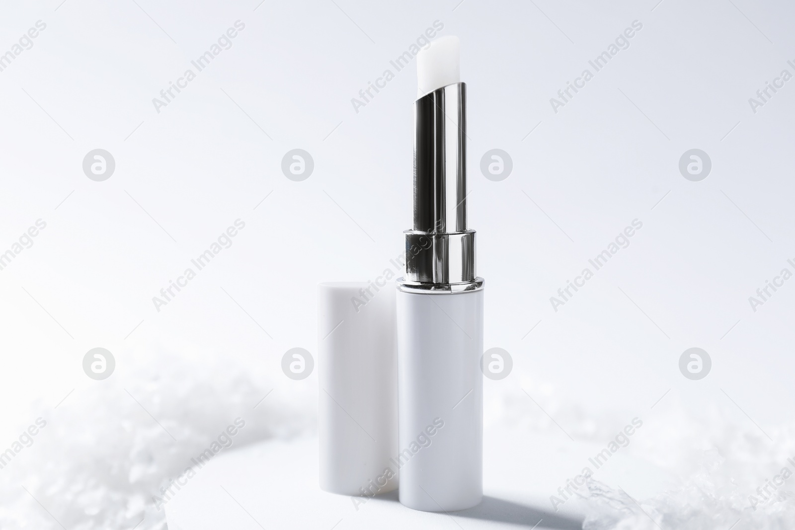 Moisturizing lip balm on artificial snow, closeup. Winter care Photo of Moisturizing lip balm on artificial snow, closeup. Winter care