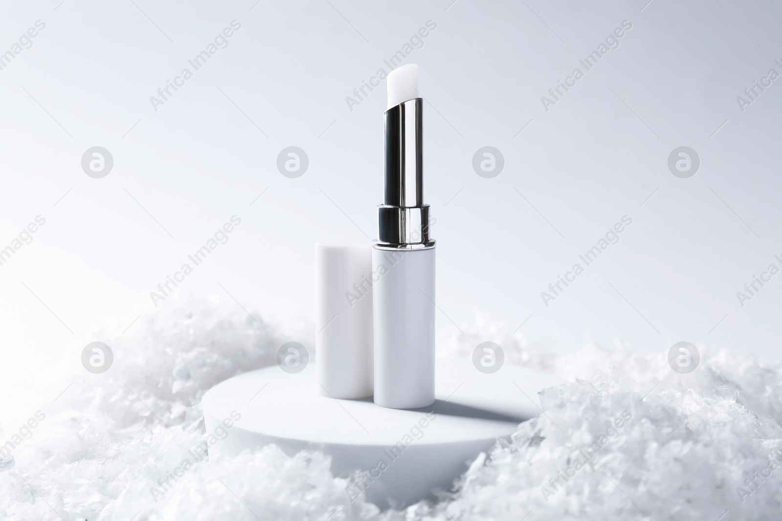 Moisturizing lip balm on artificial snow, closeup. Winter care Photo of Moisturizing lip balm on artificial snow, closeup. Winter care