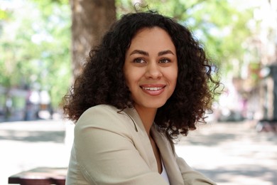 Photo of Portrait of smiling Latin American woman outdoors