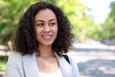 Photo of Portrait of smiling Latin American woman outdoors. Space for text