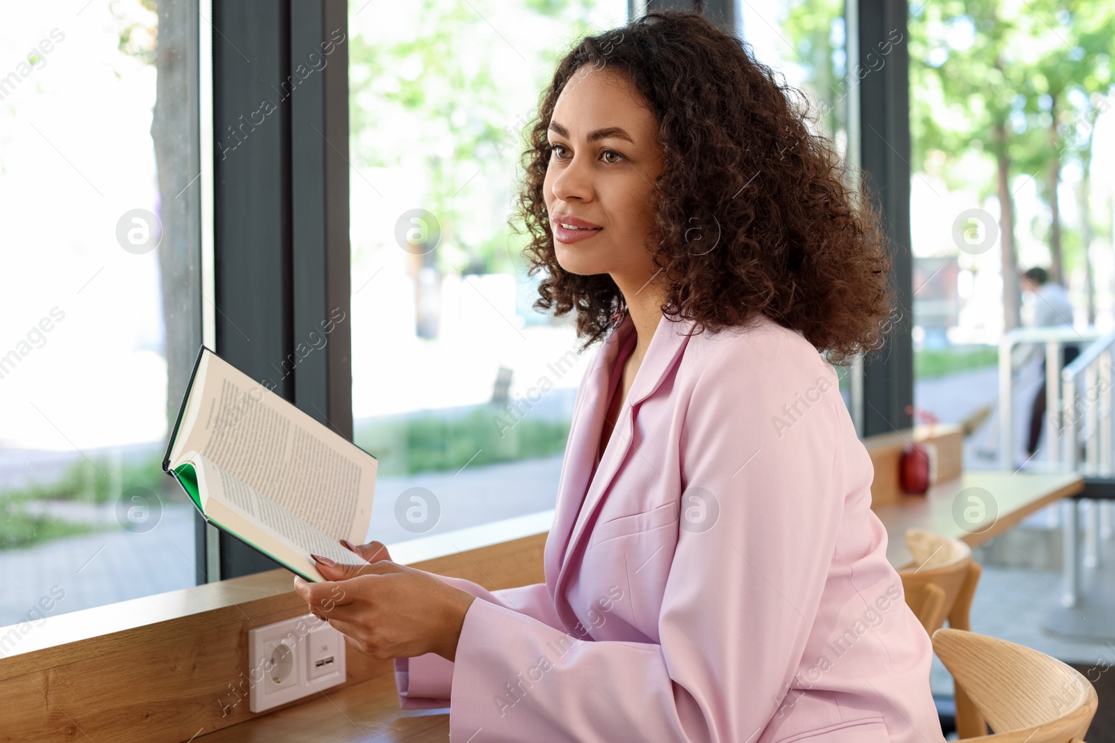 Photo of Beautiful Latin American woman reading book in cafe