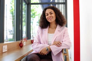 Photo of Portrait of smiling Latin American woman in cafe