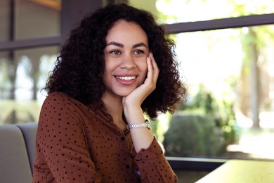 Photo of Portrait of smiling Latin American woman in cafe