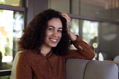 Photo of Portrait of smiling Latin American woman in cafe