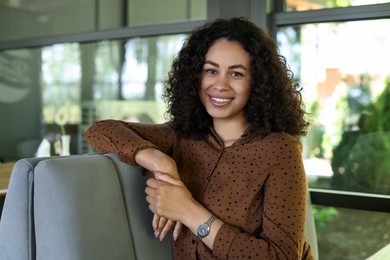 Photo of Portrait of smiling Latin American woman in cafe