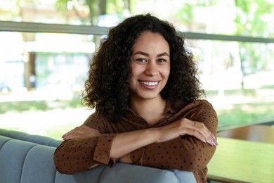 Photo of Portrait of smiling Latin American woman in cafe