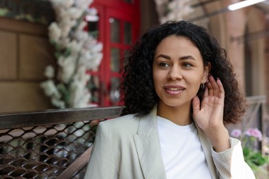 Photo of Portrait of smiling Latin American woman outdoors. Space for text