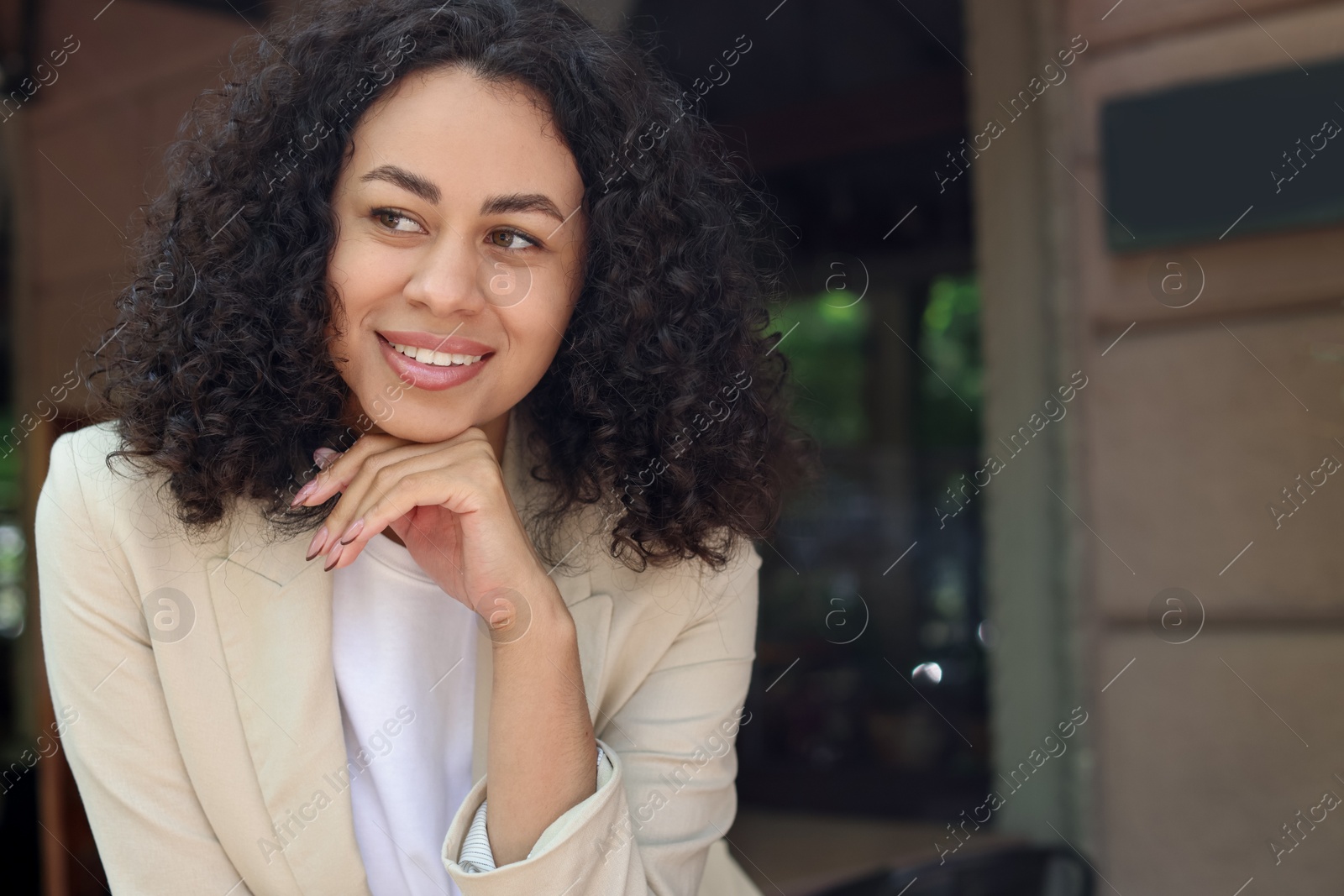 Photo of Portrait of smiling Latin American woman outdoors. Space for text