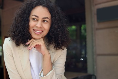 Photo of Portrait of smiling Latin American woman outdoors. Space for text