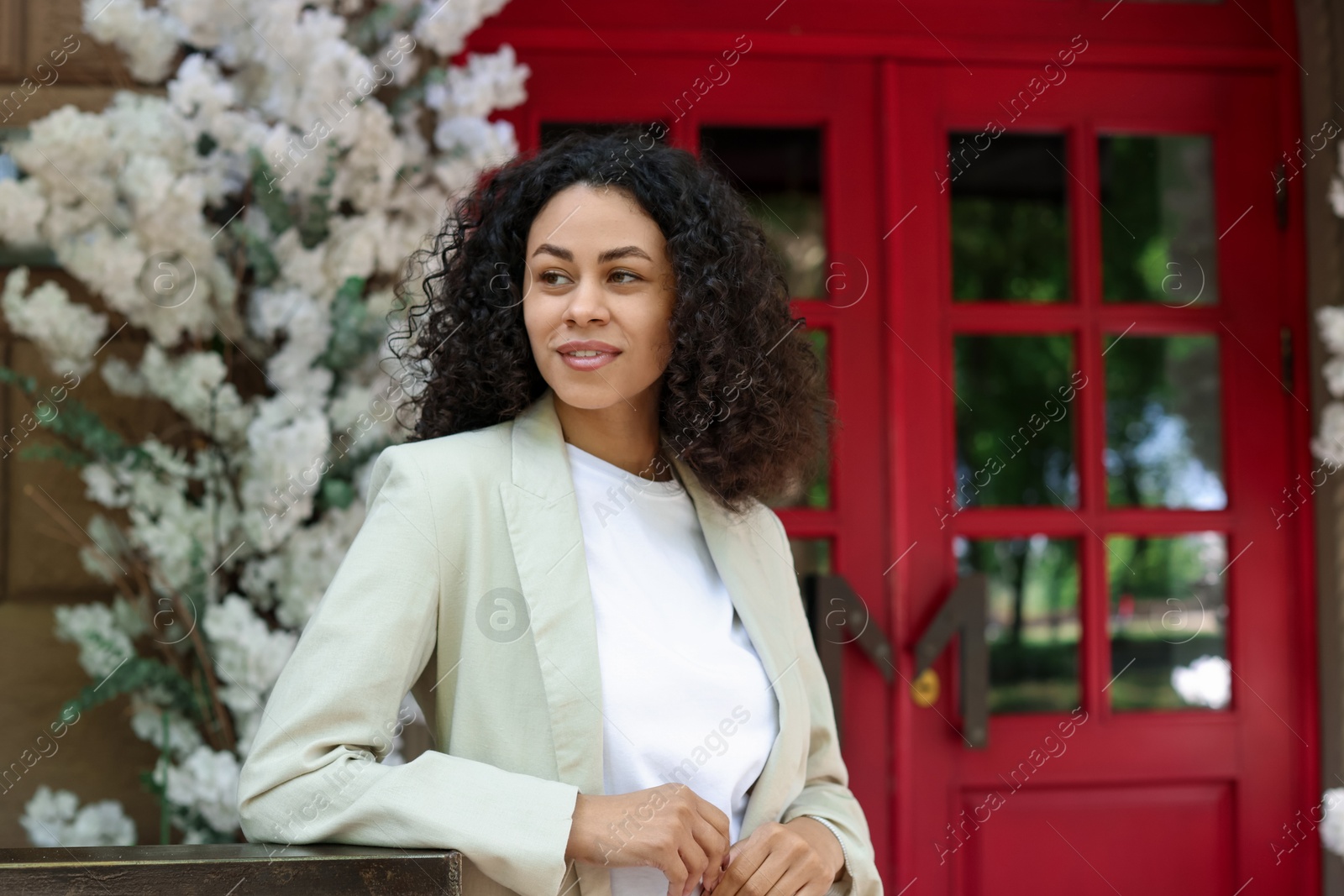 Photo of Portrait of smiling Latin American woman near building outdoors. Space for text