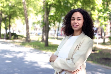 Photo of Portrait of smiling Latin American woman outdoors. Space for text