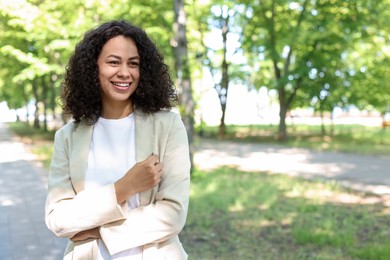 Photo of Portrait of smiling Latin American woman outdoors. Space for text