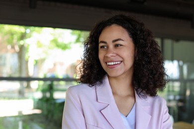 Photo of Portrait of smiling Latin American woman in cafe. Space for text