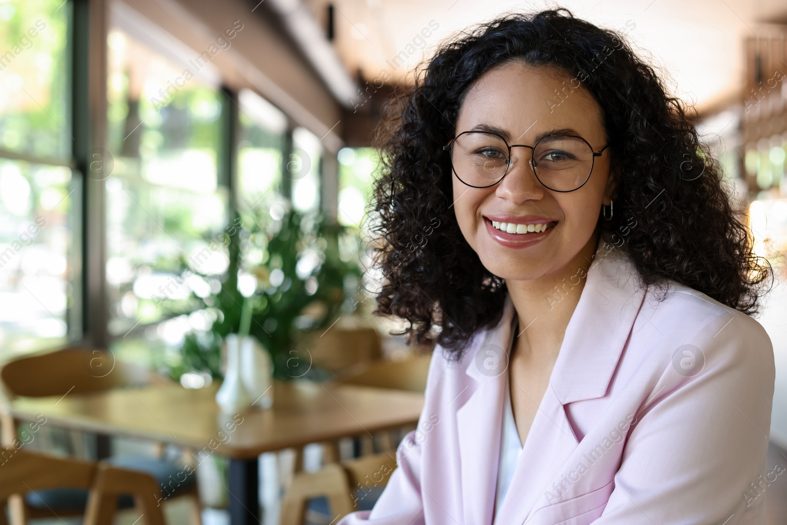 Portrait of smiling Latin American woman in cafe. Space for text Photo of Portrait of smiling Latin American woman in cafe. Space for text