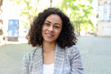 Photo of Portrait of smiling Latin American woman outdoors